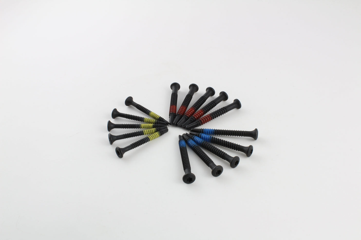 Close grouping of Lokko plug puller screws sorted by colour on a white surface
