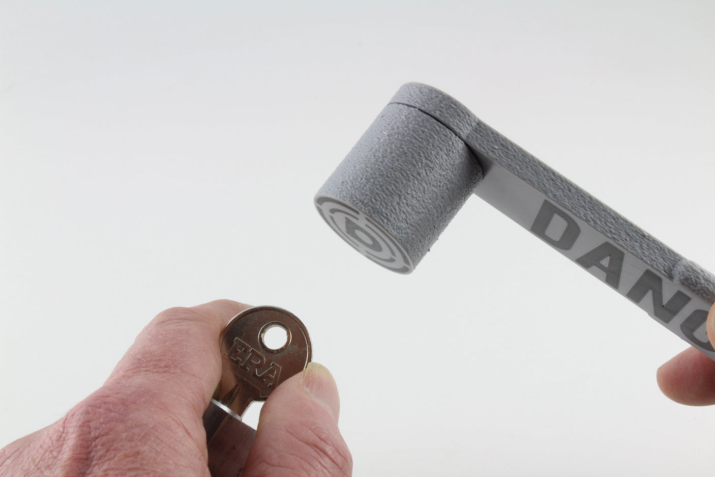 Dangerfield Bump Hammer head poised above a bump key held in a lock, ready to strike the bow