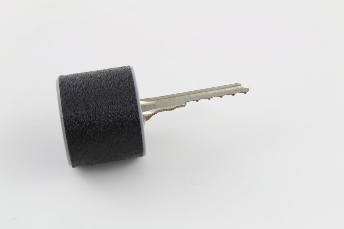 Bump key seated in the rubber dampener with the cut blade exposed, ready to slide into a cylinder