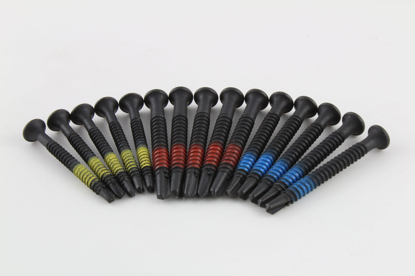 Row of fifteen Lokko extraction screws showing countersunk heads and self-tapping points by colour group
