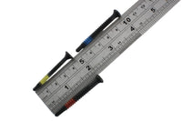 Three Lokko plug puller screws laid across a steel ruler, each around four to five centimetres long