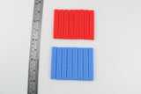 Dangerfield Praxis grip handles beside a steel ruler, red 0.6 and blue 0.4 handles shown for scale