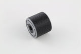Bump key dampener lying on its side showing the grey threaded cap face and textured rubber body