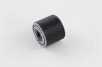 Bump key dampener lying on its side showing the grey threaded cap face and textured rubber body
