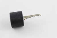 Bump key seated in the rubber dampener with the cut blade exposed, ready to slide into a cylinder