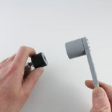Hand holding the rubber bump key dampener on a key beside the grey Dangerfield bump hammer head