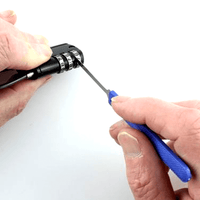 Person decoding a combination lock with a miniknife tool on a white background