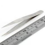 Dangerfield repinning tweezers at an angle beside a ruler for scale