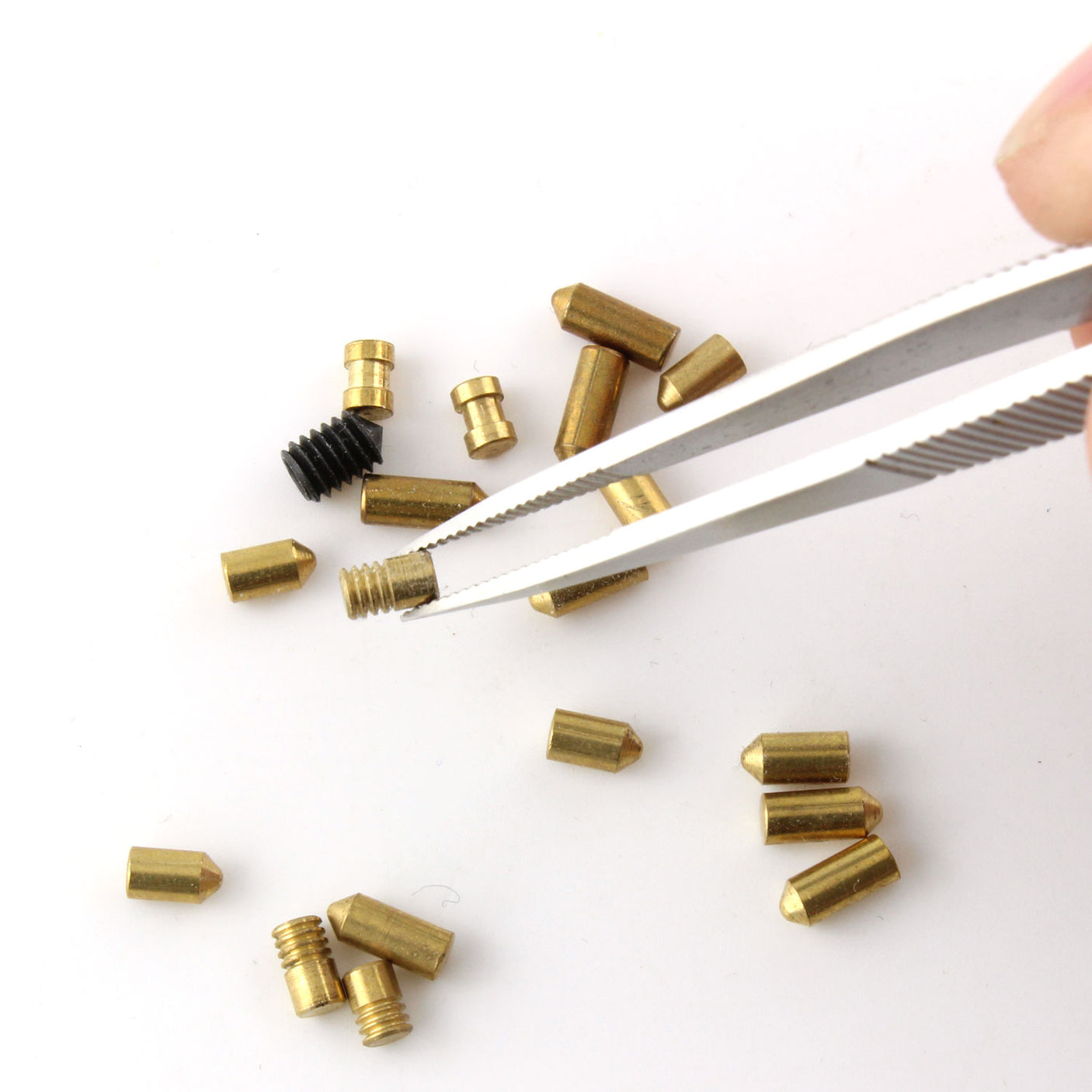Dangerfield repinning tweezers gripping a small lock component