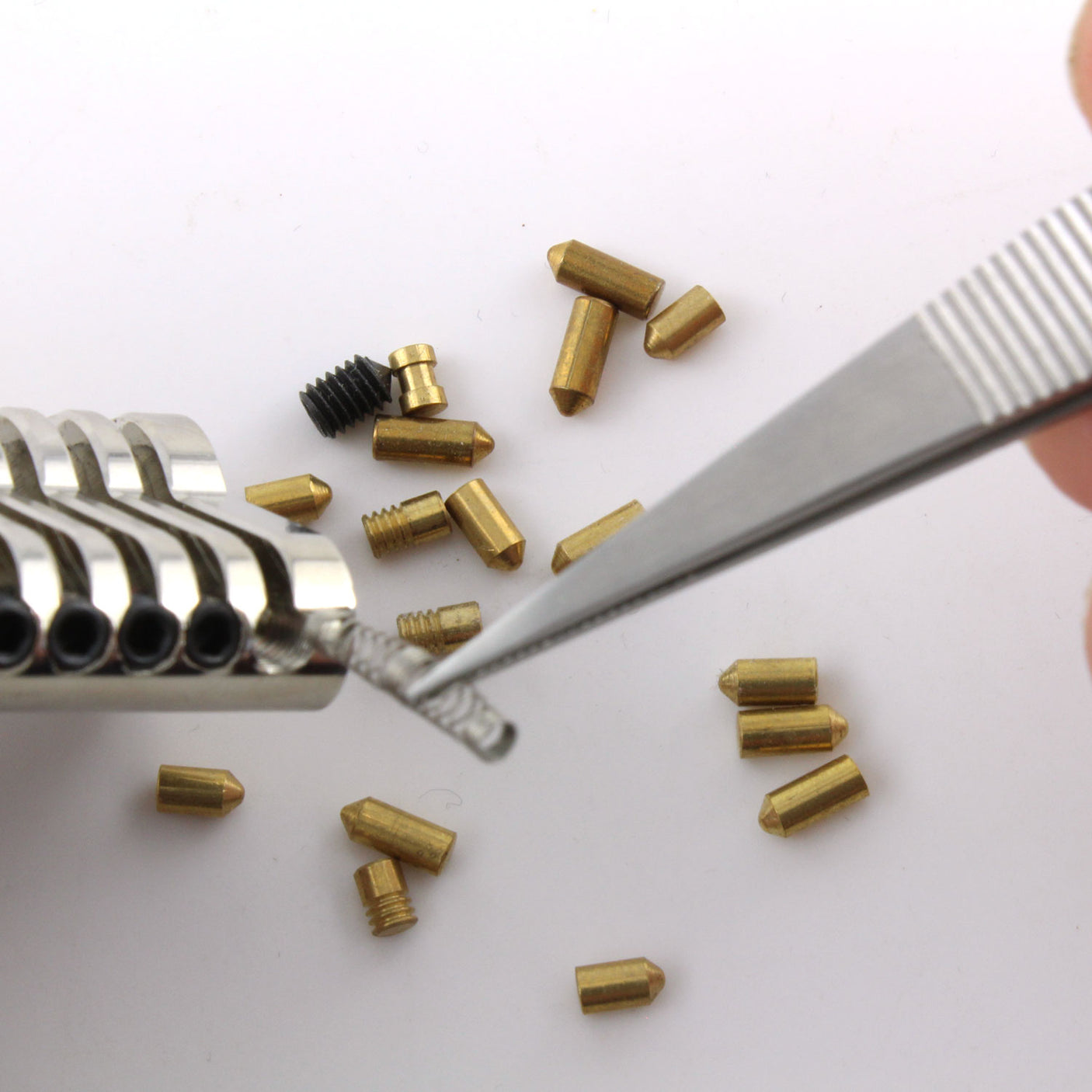 Dangerfield repinning tweezers lifting a small lock spring during pinning