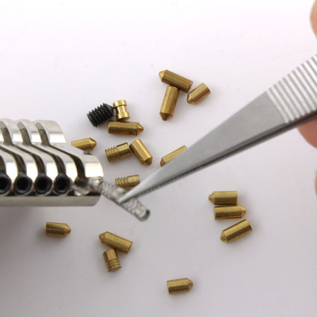 Dangerfield repinning tweezers lifting a small lock spring during pinning