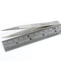 Side view of Dangerfield repinning tweezers next to a ruler for scale