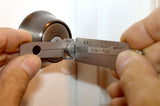 Hands using a Lishi KW1 pick on a Kwikset residential lock