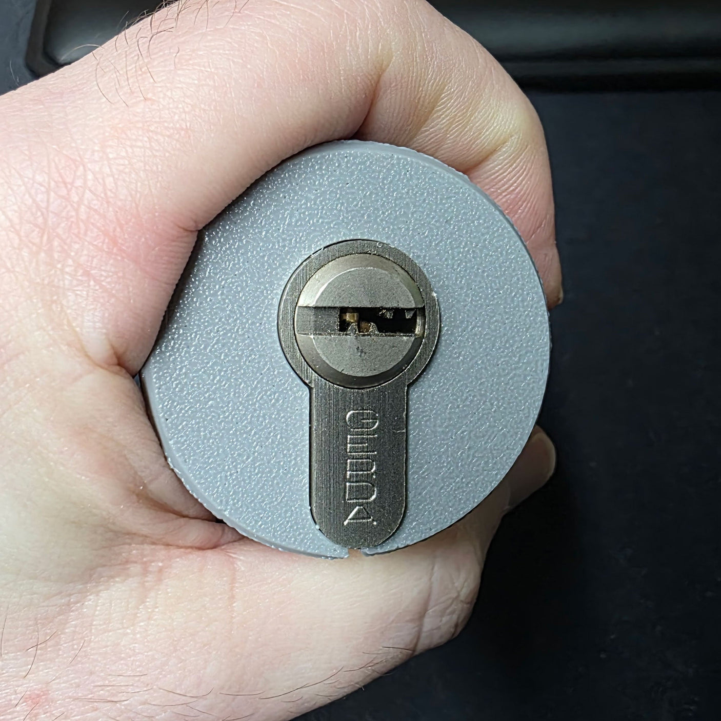Hand holding the Lokko euro cylinder hand support with a euro profile cylinder seated in the socket