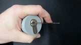 Hand cradling the Lokko euro cylinder support with a tension wrench set in the keyway ready to pick