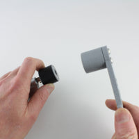 Hand holding the rubber bump key dampener on a key beside the grey Dangerfield bump hammer head